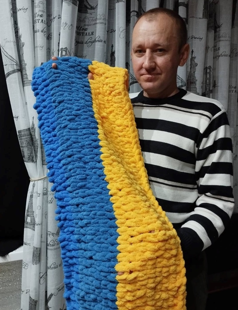 Сергій Самойленко тримає в руках шарф, який зв'язала донька.