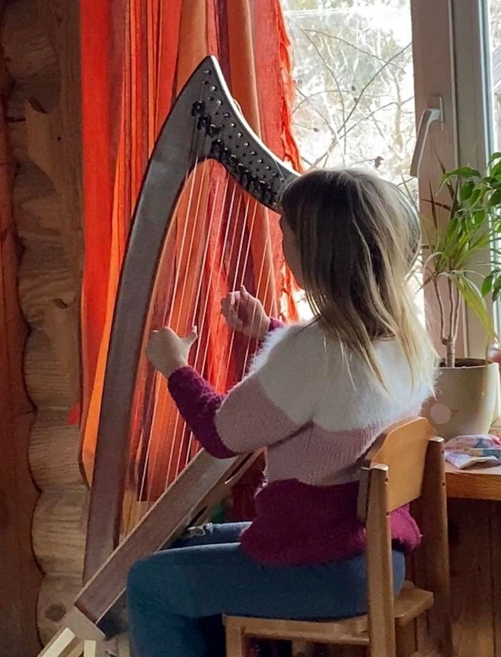 Заряна грає на арфі. Останнє фото у будинку
