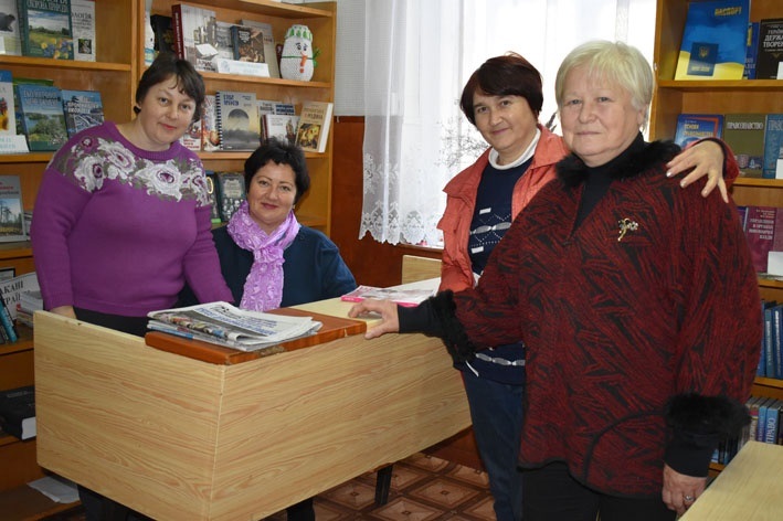 Світлана Харіна (праворуч) зі своїми колегами у читальній залі бібліотеки