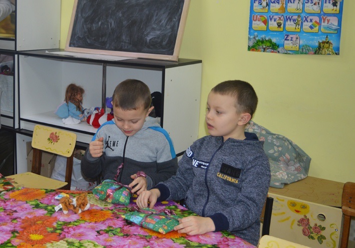 Діти роздивляються подарунки від італійських школярів