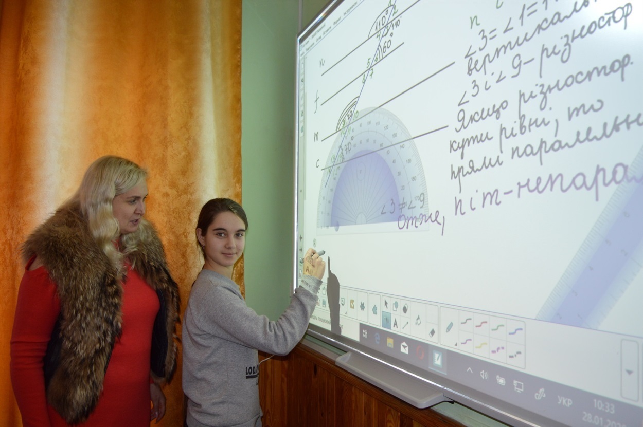 Учителька Світлана Ковтун та учениця Настя Риченко на уроці математики працюють з новими технологіями  