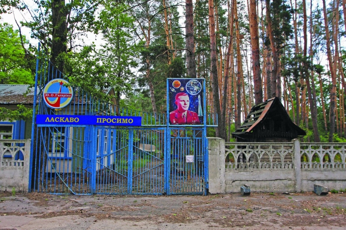 Ворота в дитячий табір імені Гагаріна в Ірпені. Тут міська влада пропонує жити тим, хто втратив дах над головою. На території запустіння, в корпусах побиті шибки. Ремонту ніде не помітно