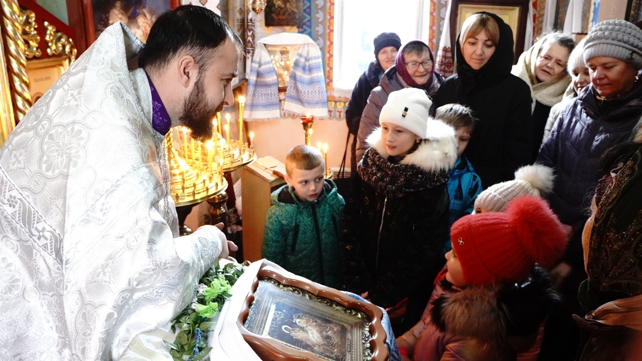 Отець Дмитро слухає маленьких колядників