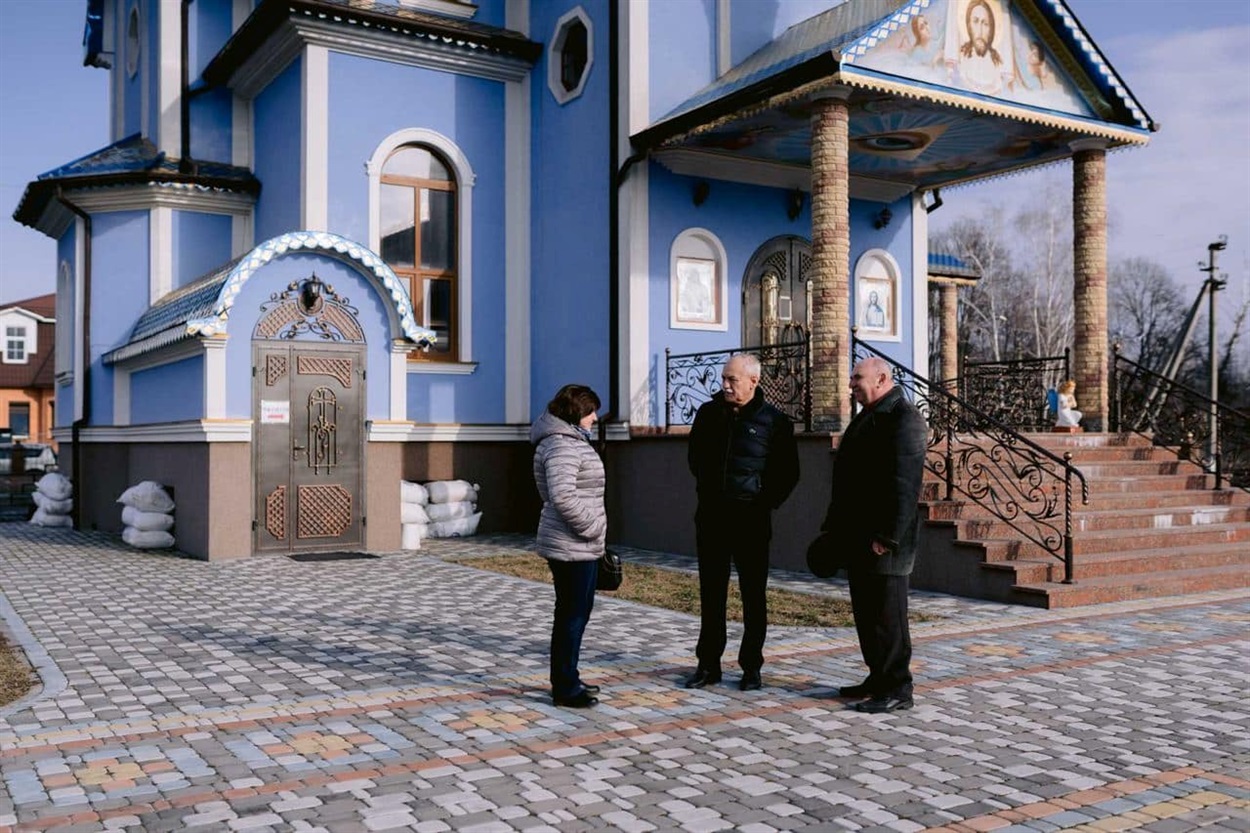Біля Володимирського храму в Переяславі (мікрорайон Підварки) заступниця міського голови Оксана Степаненко, міський голова Вячеслав Саулко, директор гімназії №4 Анатолій Чуян. Позаду праворуч від східців до головного входу – вхід до укриття для учнів.