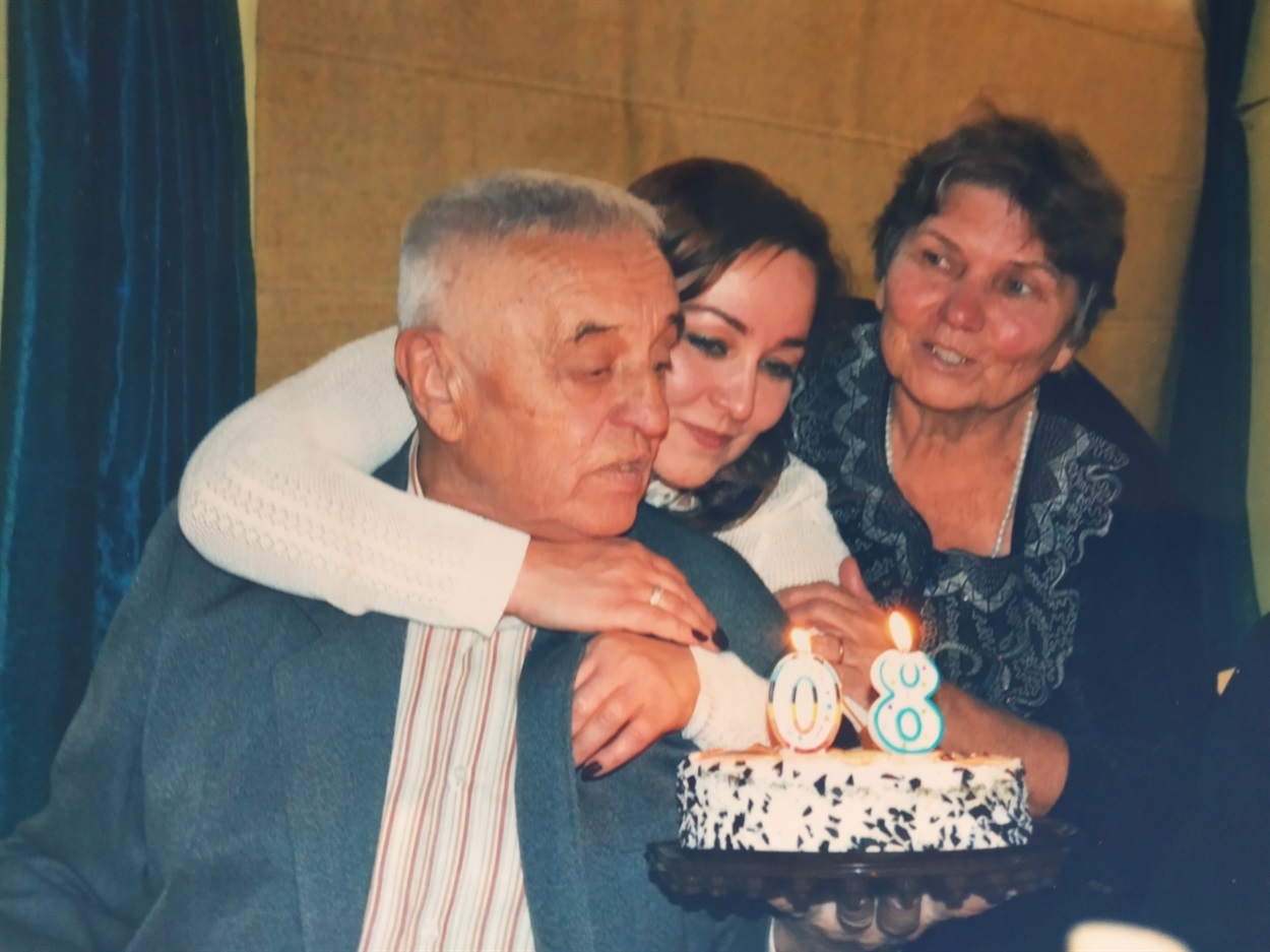 Олександр Павлович із донькою та дружиною задуває свічки на торті на своєму 80-річчі