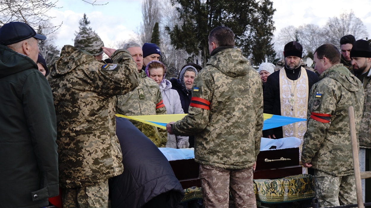 Володимир Іванович передає рідним захисника прапор держави, за яку він загинув