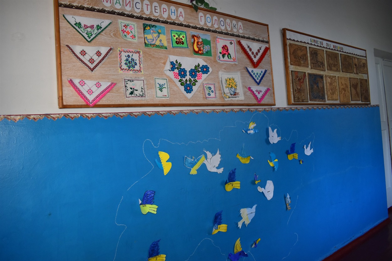 У шкільному коридорі стіни прикрашають дитячі роботи 