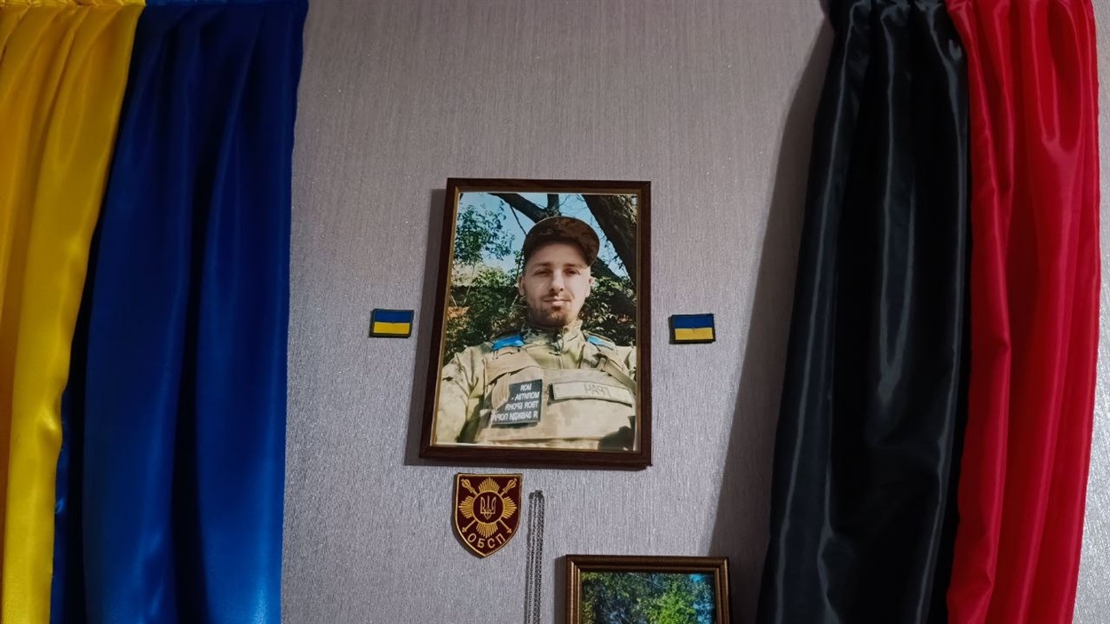 Шеврони і фото в куточку пам'яті про сина в  родинній оселі Світлани та Миколи Шкварів 
