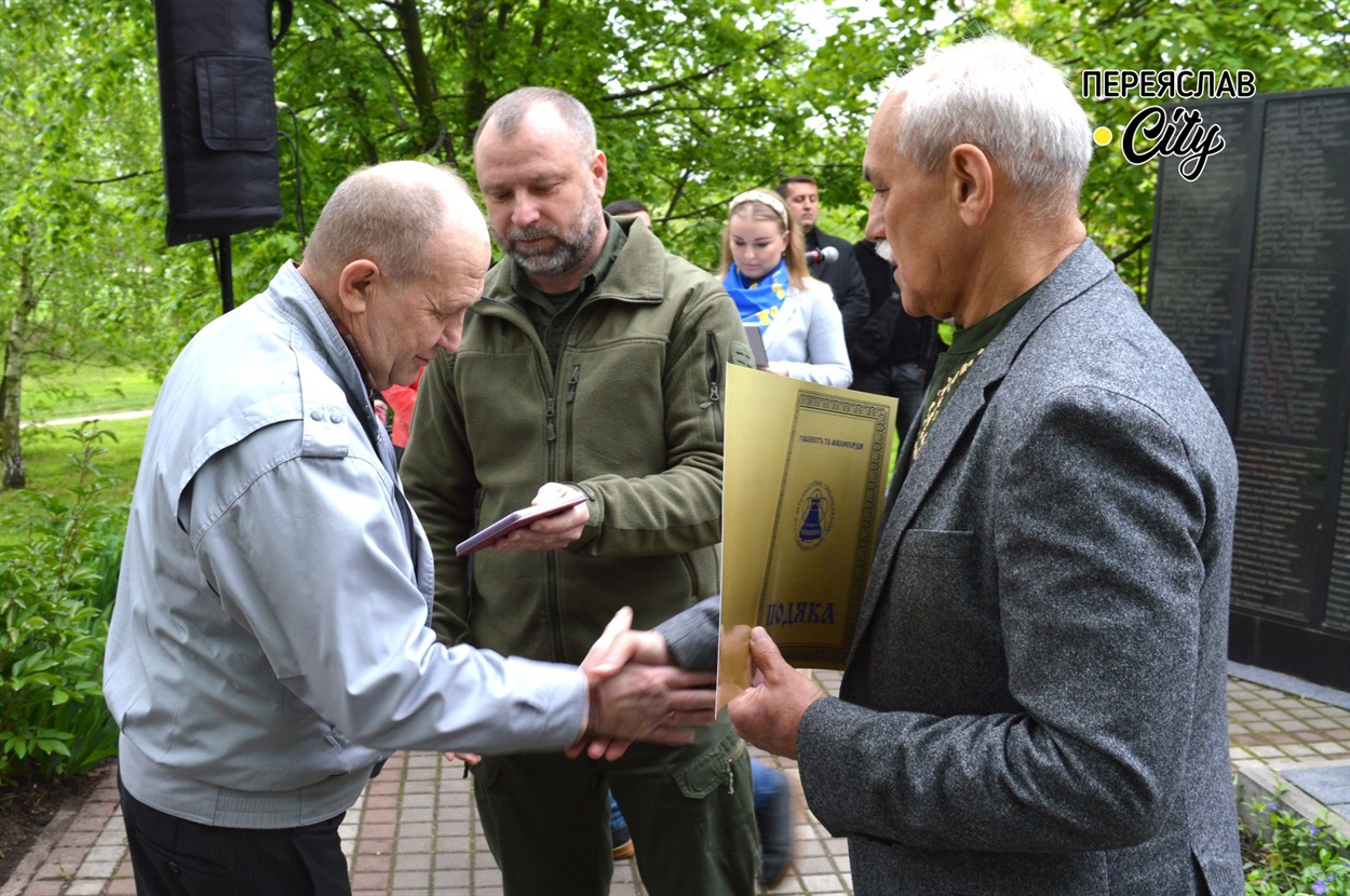 Міський голова та очільник Бориспільської РДА Руслан Дяченко вручають відзнаку Миколі Кураченку
