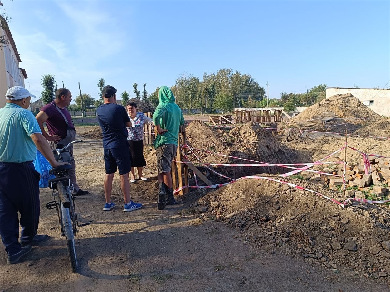 Тетяна Касьян  обговорює з працівниками ВУКГ можливість заміни водопровідної труби, з велосипедом стоїть Василь Березовий