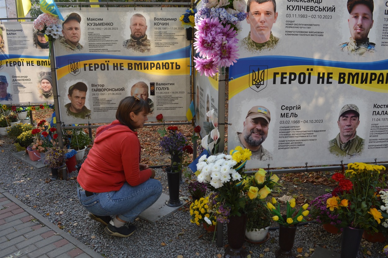 Оксана Стратієнко біля портрета свого полеглого чоловіка Сергія Стратієнка