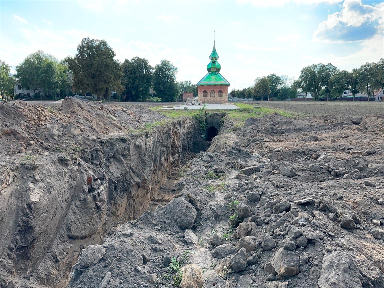 Траншея завглибшки зо три метри, викопана спецтехнікою на рівні підлоги від монастирського льоху (після приватної реставрації з зеленим дашком) вирита Г-подібно в бік собору