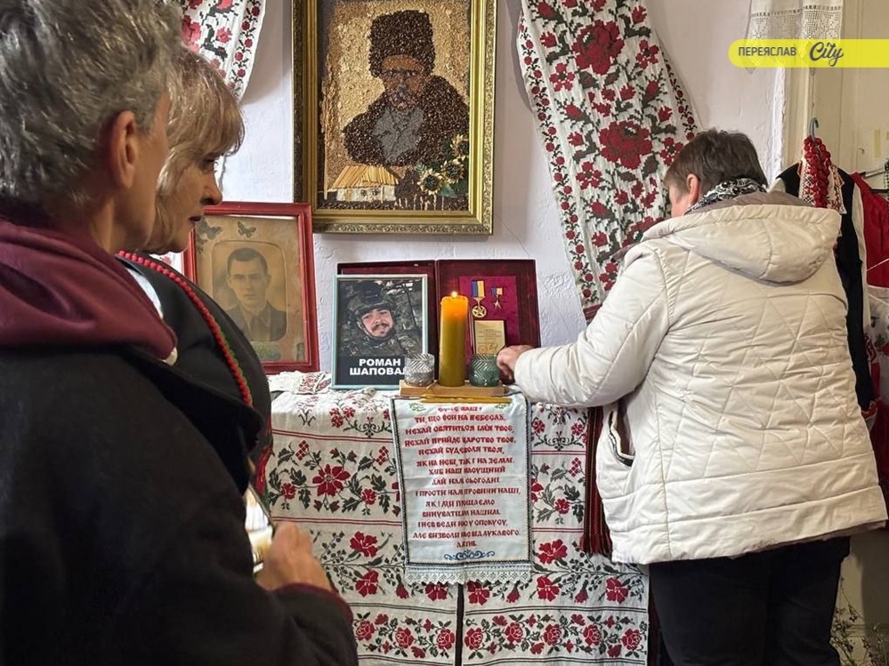 Лариса Шаповал запалює свічку пам'яті біля портрета сина Романа зустрічі в центрі "Любомир" у Переяславі