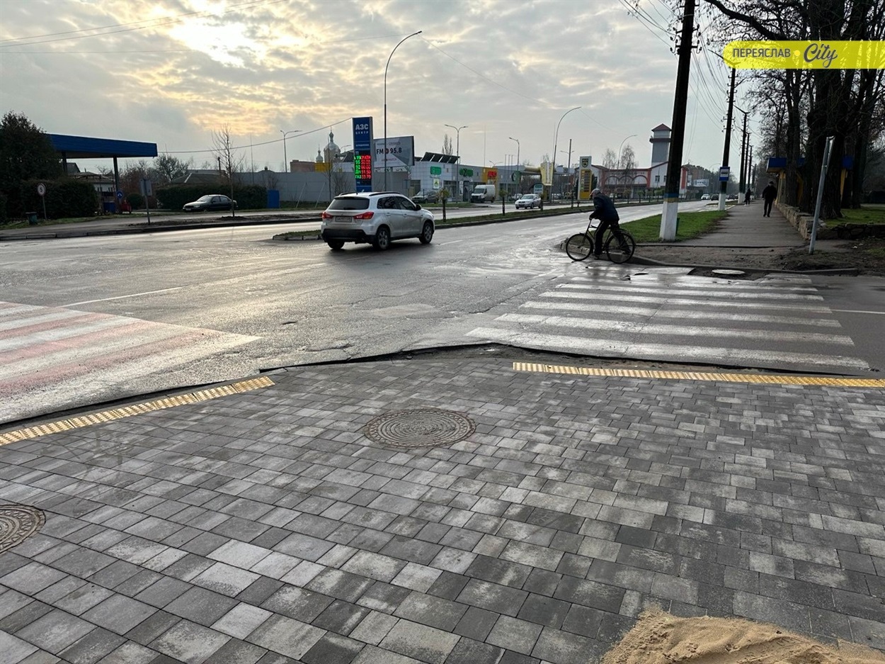 Тротуар з пологими спусками до переходу і тактильними жовтими елементами інклюзивного доступу