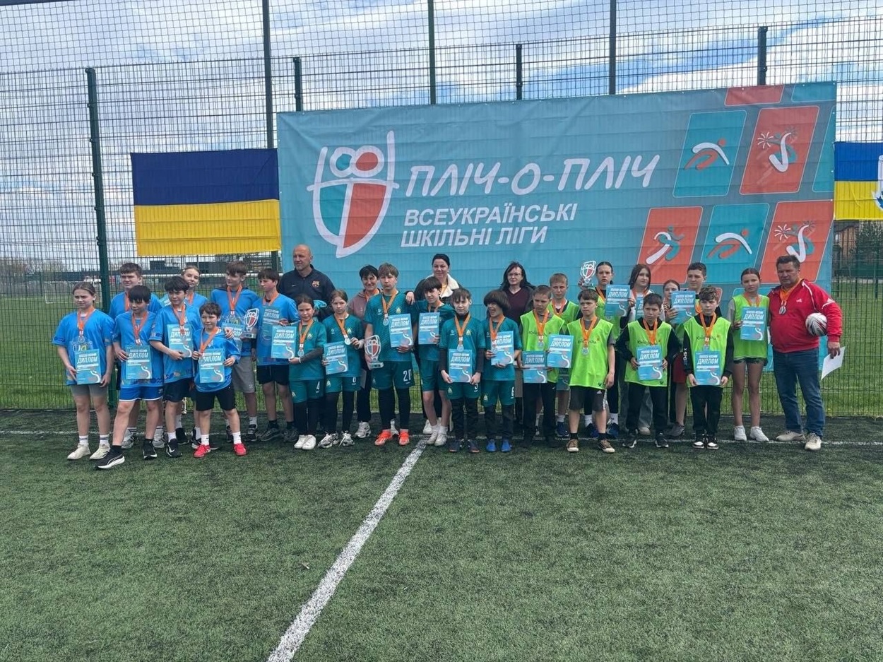 Команда юних регбістів Дем'янецької гімназії праворуч у формі салатового кольору поряд із наставником Миколою Погребним 